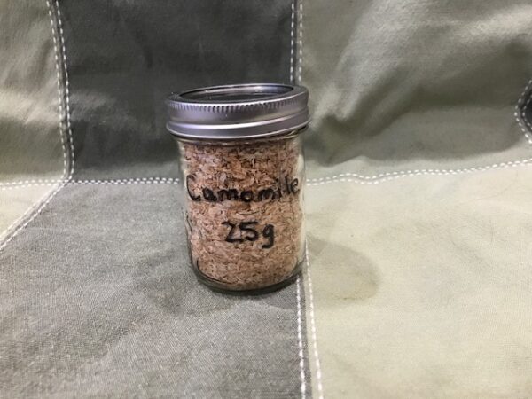 A 250 ml mason jar containing dried white camomile petals